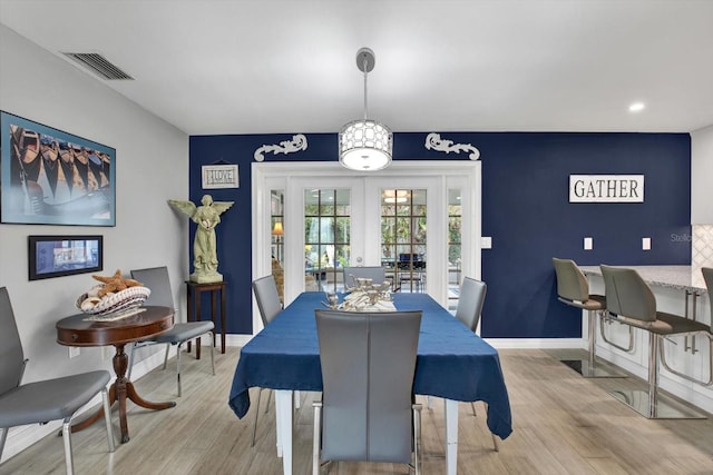 dining area featuring light wood-style flooring, visible vents, baseboards, and french doors