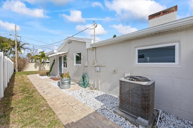 rear view of property with cooling unit and a patio