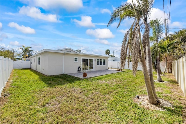 rear view of property featuring a patio area and a yard