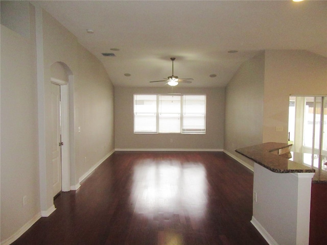 unfurnished living room featuring ceiling fan, vaulted ceiling, and dark hardwood / wood-style flooring