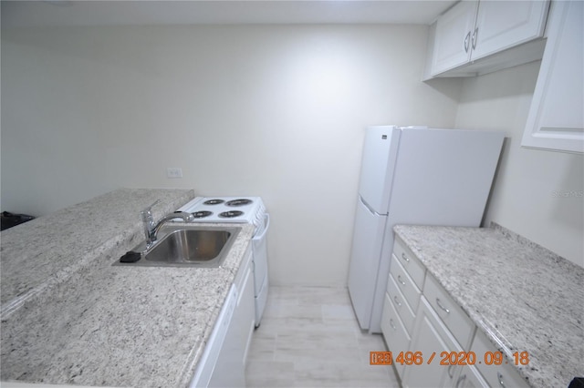 kitchen with light stone countertops, sink, white appliances, and white cabinets