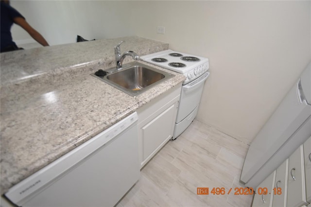 kitchen featuring white cabinets, light stone counters, sink, and white appliances