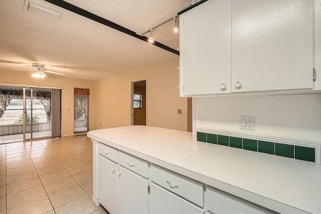 kitchen featuring ceiling fan, white cabinets, light tile patterned floors, track lighting, and a textured ceiling