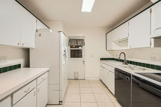 kitchen featuring sink, light tile patterned flooring, white cabinetry, and black dishwasher