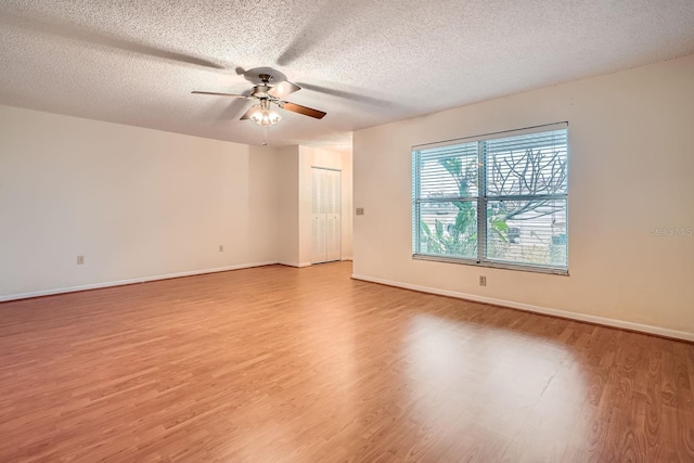 unfurnished room with light hardwood / wood-style floors, a textured ceiling, and ceiling fan