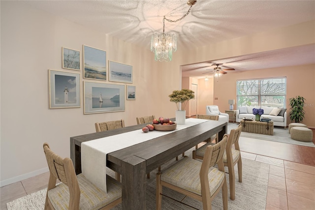 dining space featuring ceiling fan with notable chandelier, a textured ceiling, and light tile patterned flooring