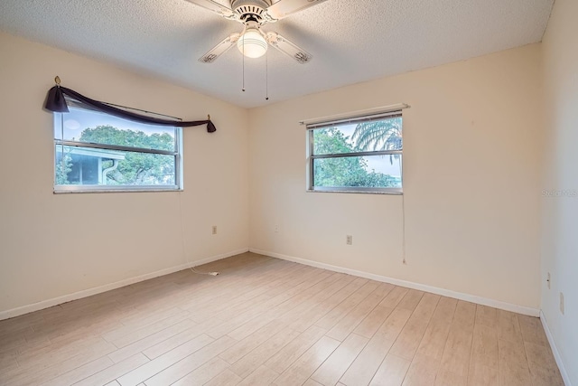 unfurnished room with ceiling fan, a textured ceiling, and light wood-type flooring