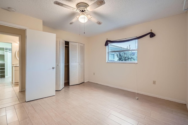 unfurnished bedroom featuring a textured ceiling, two closets, and ceiling fan