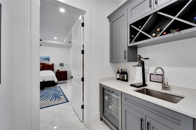 interior space with wine cooler, sink, and gray cabinets