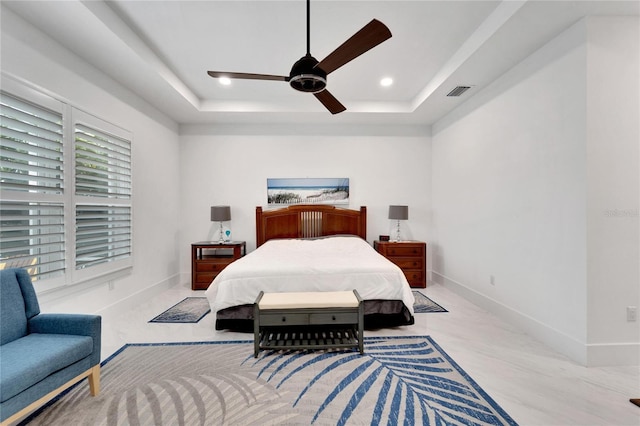 bedroom featuring ceiling fan and a raised ceiling