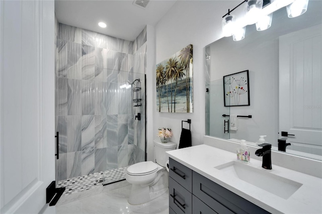 bathroom featuring tiled shower, vanity, and toilet