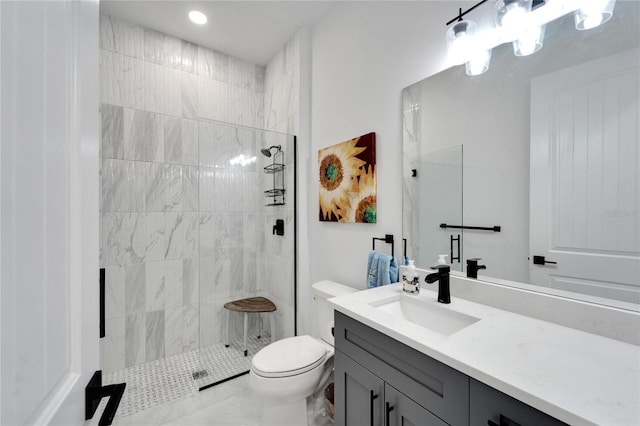 bathroom featuring toilet, vanity, and a tile shower