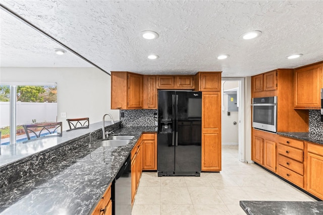 kitchen featuring dark stone countertops, sink, backsplash, and black appliances