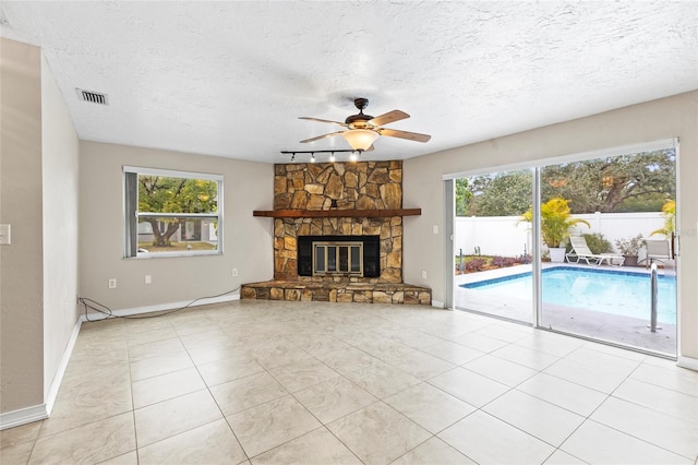 unfurnished living room with light tile patterned flooring, a fireplace, and a wealth of natural light