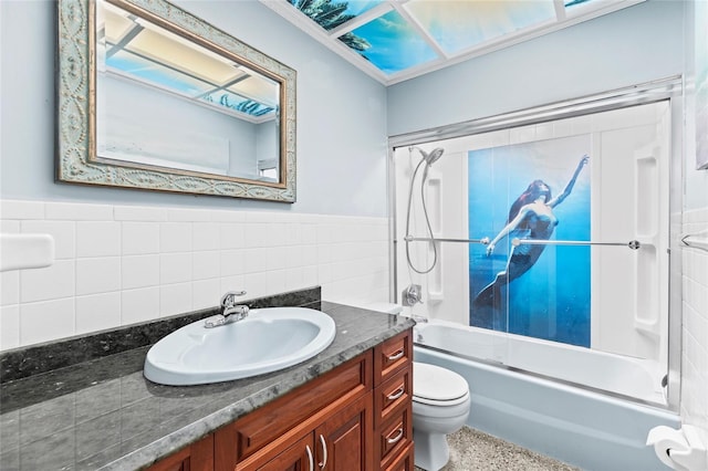 full bathroom with toilet, vanity, bathtub / shower combination, and tile walls