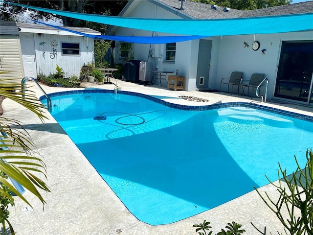 view of swimming pool featuring an outbuilding