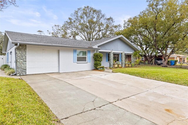 ranch-style house featuring a garage and a front lawn