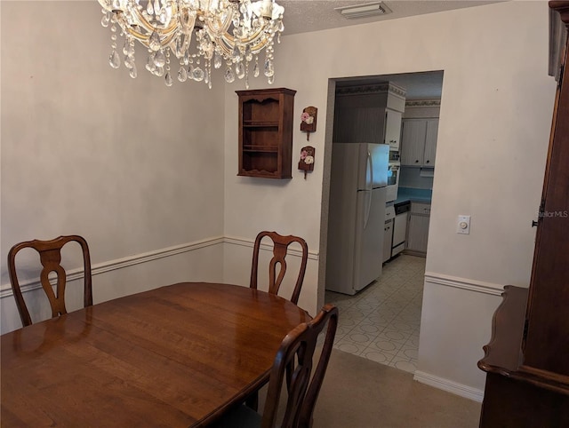 dining area featuring a textured ceiling and a notable chandelier