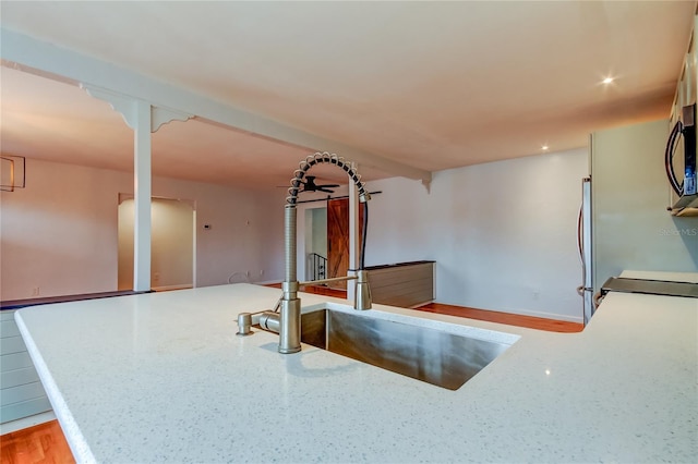 kitchen with light stone countertops, sink, and range