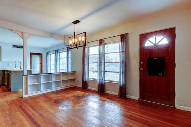 foyer featuring sink, a chandelier, and hardwood / wood-style floors