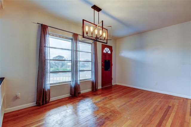 foyer entrance featuring wood-type flooring and a chandelier