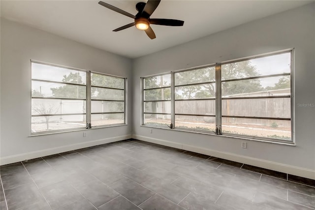 tiled spare room with ceiling fan and plenty of natural light