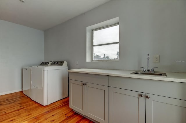 washroom featuring cabinets, washer and dryer, light hardwood / wood-style floors, and sink