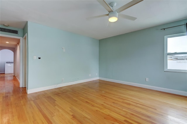 empty room with ceiling fan, washer / clothes dryer, and light hardwood / wood-style flooring