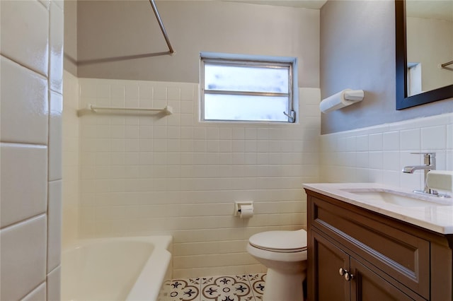 full bathroom with toilet, tile walls, tile patterned floors,  shower combination, and vanity