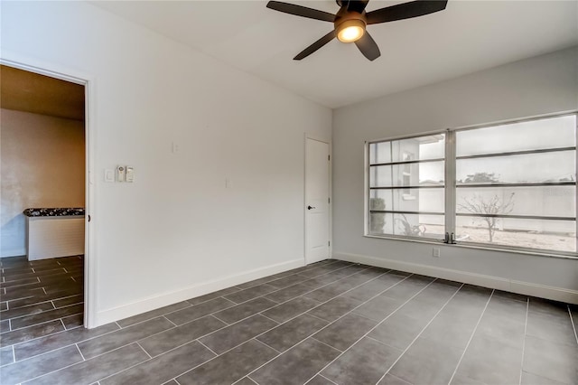 tiled empty room featuring ceiling fan