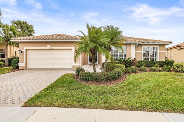 mediterranean / spanish-style house with a garage and a front lawn