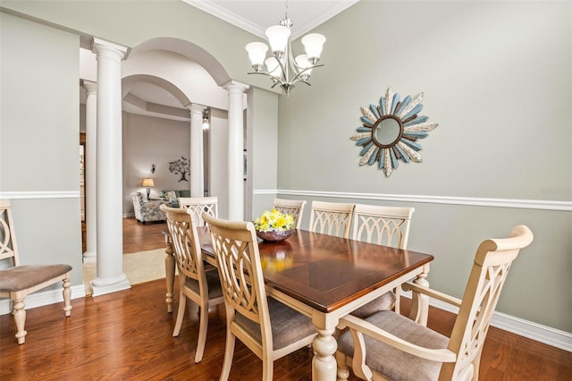 dining space featuring wood-type flooring, a notable chandelier, and crown molding