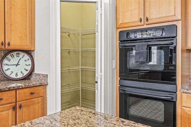 kitchen with light stone counters and double oven