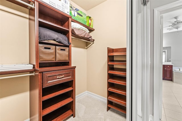 spacious closet with ceiling fan and light tile patterned flooring