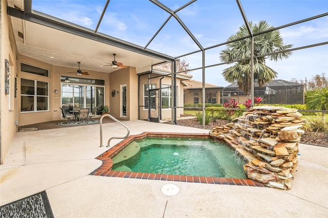 view of pool with ceiling fan, a patio area, and glass enclosure