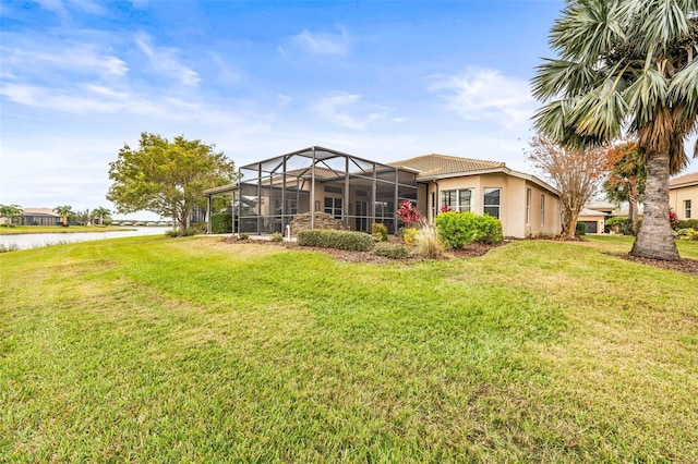 back of property featuring a lanai, a water view, and a yard