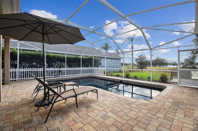 view of swimming pool with glass enclosure and a patio