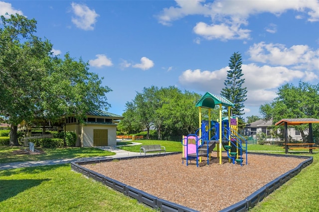 view of playground featuring a storage shed and a yard