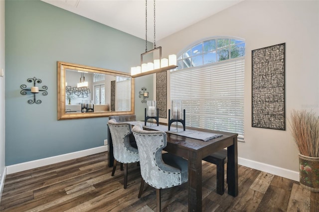 dining area featuring dark wood-type flooring and an inviting chandelier