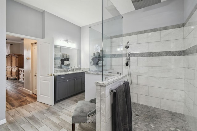 bathroom with a tile shower and vanity