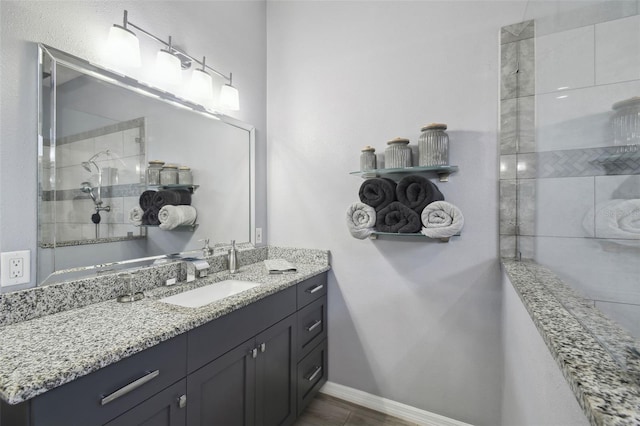 bathroom with vanity and a tile shower