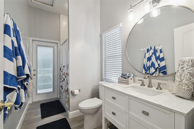 bathroom with toilet, vanity, curtained shower, and hardwood / wood-style floors