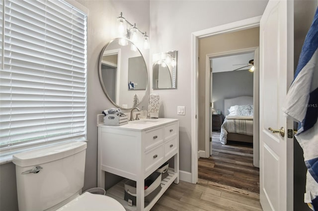 bathroom featuring ceiling fan, vanity, toilet, and hardwood / wood-style flooring