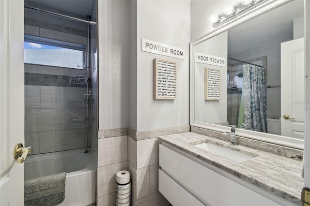 bathroom featuring tile walls, vanity, and shower / tub combo