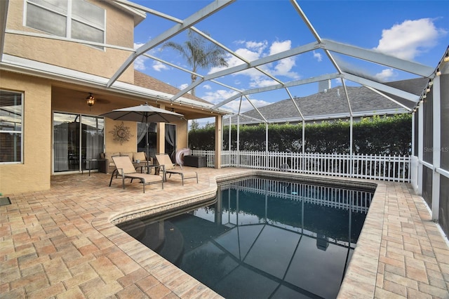 view of pool featuring glass enclosure and a patio area