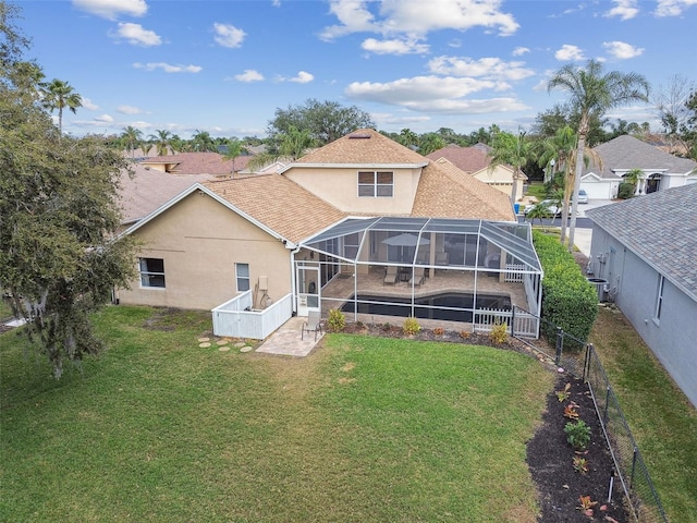 rear view of property with a lanai and a yard