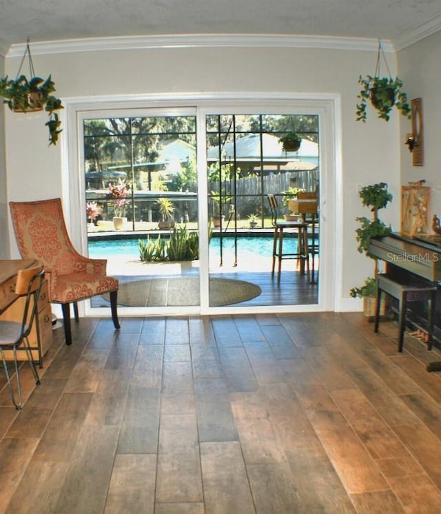 entryway featuring crown molding, dark wood-type flooring, and a wealth of natural light