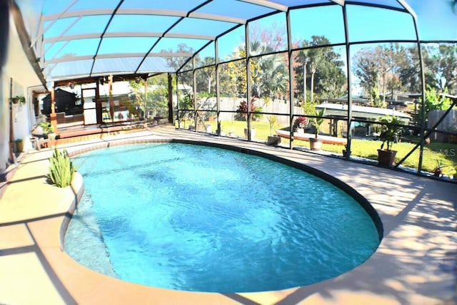 view of swimming pool with glass enclosure and a patio area