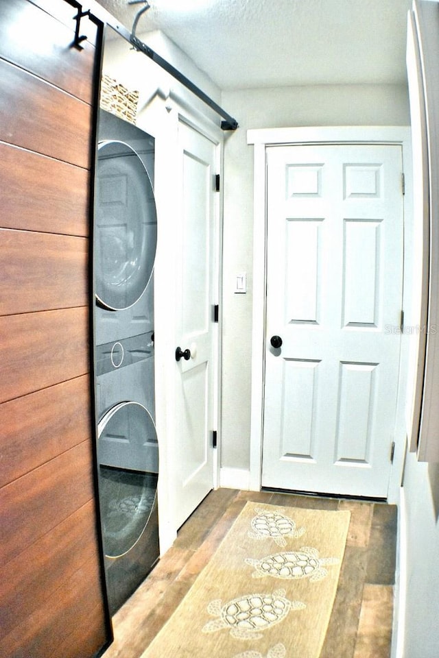 clothes washing area featuring stacked washer / dryer