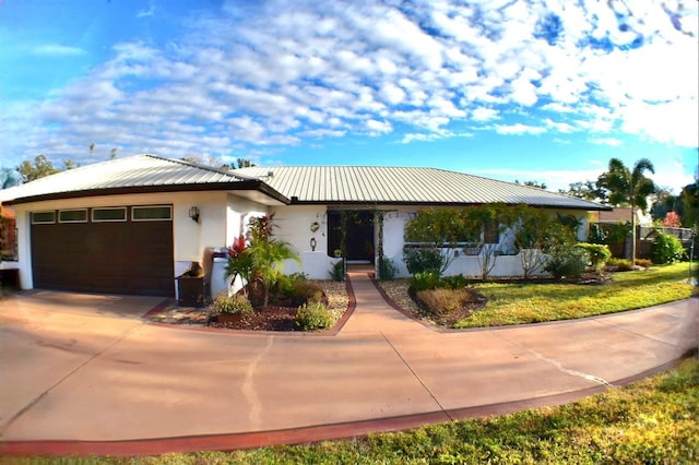 225 Temple Cir, Eustis, FL 32726 - view of front facade featuring stucco siding, a garage, driveway, and metal roof